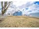 Spacious backyard showcasing a blue two-story home under a partly cloudy sky on a sprawling lawn at 300 E North Main St, Summitville, IN 46070