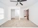 Bright bedroom with neutral carpet, ceiling fan, closet with mirrored sliding doors and open doorway at 300 E North Main St, Summitville, IN 46070