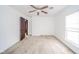 A bright and airy bedroom featuring neutral carpet, a ceiling fan, two windows, and an open doorway at 300 E North Main St, Summitville, IN 46070