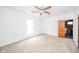 Bedroom features neutral carpet, ceiling fan, natural light, and access to a unique bathroom at 300 E North Main St, Summitville, IN 46070