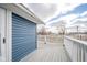 Deck view with white railing and siding with blue home at 300 E North Main St, Summitville, IN 46070