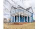 Charming two-story blue home with a covered porch, white pillars, and an upper-level deck at 300 E North Main St, Summitville, IN 46070