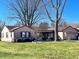 Charming single-story home with well-maintained lawn and mature trees on a sunny day at 327 Maxwell Rd, Indianapolis, IN 46217