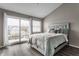 Bedroom with modern gray tones featuring balcony, hard wood flooring, and accent pillows at 3278 Oceanline E Dr, Indianapolis, IN 46214