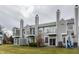 Townhome exterior featuring balconies, gray siding, chimneys, and a well-maintained grassy area at 3278 Oceanline E Dr, Indianapolis, IN 46214