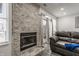 Living room with a stone fireplace, large windows, and modern grey vinyl flooring at 3278 Oceanline E Dr, Indianapolis, IN 46214