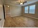 A well-lit bedroom with wood-look floors, a ceiling fan, and two windows offers a relaxing space at 3408 Village Dr, Anderson, IN 46011