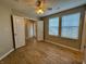 Spacious bedroom with a ceiling fan, wood-look flooring, and natural light from two windows at 3408 Village Dr, Anderson, IN 46011
