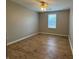 A serene bedroom features hardwood floors, a ceiling fan, and a window for ample natural light at 3408 Village Dr, Anderson, IN 46011