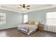 Bright bedroom featuring a ceiling fan, wood floors, and natural light from two large windows at 3423 Shadow Bend Dr, Columbus, IN 47201