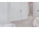 Hallway with neutral walls and floors leading to a separate room with white doors at 3550 N Illinois St, Indianapolis, IN 46208