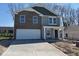 Two-story home featuring a brick facade, gray siding, and a spacious two-car garage at 3825 Windstar Way, Columbus, IN 47203