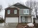Charming two-story home featuring brick and gray siding, a two-car garage, and a welcoming front porch at 3825 Windstar Way, Columbus, IN 47203