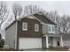 This charming two-story home features brick and gray siding, a two-car garage, and a welcoming front porch at 3825 Windstar Way, Columbus, IN 47203