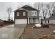 Charming two-story home featuring brick and gray siding, a two-car garage, and a welcoming front porch at 3825 Windstar Way, Columbus, IN 47203
