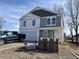 Two-story home with gray siding, white trim, and stacked brick pallets in the yard at 3825 Windstar Way, Columbus, IN 47203
