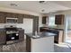 Well-lit kitchen with stainless steel appliances, dark countertops, and an island at 3825 Windstar Way, Columbus, IN 47203