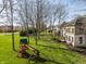 A spacious backyard with a playset, mature trees, a lush lawn, and a view of the home's back exterior at 4243 Riverbirch Run, Zionsville, IN 46077