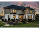 Gorgeous backyard with a deck for entertaining, lush lawn, and manicured landscaping at twilight at 4243 Riverbirch Run, Zionsville, IN 46077