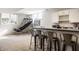 Finished basement bar with seating, bar area, and basketball hoop behind at 4243 Riverbirch Run, Zionsville, IN 46077