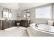 Elegant primary bathroom featuring dual vanities, a soaking tub and neutral color palette at 4243 Riverbirch Run, Zionsville, IN 46077