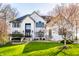 Beautiful two-story white brick home featuring a well-manicured lawn and modern black trim windows at 4243 Riverbirch Run, Zionsville, IN 46077