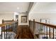 Second-floor hallway showcasing hardwood floors and decorative wrought iron railings and ornate detailing at 4243 Riverbirch Run, Zionsville, IN 46077