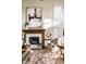 Living room featuring a fireplace, tall bright windows, and comfortable seating with a decorative ottoman at 4243 Riverbirch Run, Zionsville, IN 46077