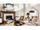 Cozy living room with a fireplace, tall windows, and comfortable seating create a warm and inviting space at 4243 Riverbirch Run, Zionsville, IN 46077