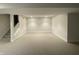 A neutral carpeted finished basement with staircase, recessed lights, and bright white trim at 5421 Upper Garden Way, Zionsville, IN 46077