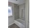 Bathroom features modern tile surround, bathtub and shower combo with an insert shelves at 5421 Upper Garden Way, Zionsville, IN 46077