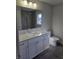 Modern bathroom boasts double vanity, granite countertop, sleek tile, and updated fixtures at 5421 Upper Garden Way, Zionsville, IN 46077