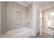 Clean bathroom with a tiled tub-shower and an open door leading to a bedroom at 5421 Upper Garden Way, Zionsville, IN 46077