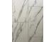 Close up on new bathroom tiles with a marble pattern and gray grout at 5421 Upper Garden Way, Zionsville, IN 46077