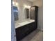 Bathroom vanity with double sinks, framed mirrors, and dark wood cabinets at 5421 Upper Garden Way, Zionsville, IN 46077