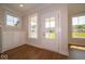 Bright entryway featuring hardwood floors, built-in cabinets, and a glass-paneled front door at 5421 Upper Garden Way, Zionsville, IN 46077