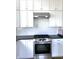 Stainless steel stove and vent hood with white cabinets and subway tile backsplash at 5421 Upper Garden Way, Zionsville, IN 46077