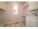 The laundry room features a utility sink, ample cabinet space, and a bright window at 5421 Upper Garden Way, Zionsville, IN 46077