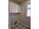 Laundry area featuring built-in cabinets and hookups with neutral diamond tile floor at 5421 Upper Garden Way, Zionsville, IN 46077