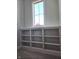 Close-up view of the built-in shelving at the top of the staircase, bathed in natural light at 5421 Upper Garden Way, Zionsville, IN 46077