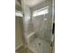 Modern shower featuring marble-style tiling, a built-in seat, and a sleek glass door at 5421 Upper Garden Way, Zionsville, IN 46077