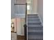 View from the top of the staircase, with wooden handrail and carpeted steps at 5421 Upper Garden Way, Zionsville, IN 46077