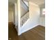 Elegant staircase with wooden handrail and white risers, complemented by hardwood flooring at 5421 Upper Garden Way, Zionsville, IN 46077