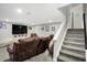 Finished basement featuring a large seating area, mounted TV, and staircase access to the upper level at 5683 Oakmont Blvd, Bargersville, IN 46106