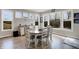 Bright dining area features three windows offering view of the surrounding backyard landscape and a lovely oval dining table at 5683 Oakmont Blvd, Bargersville, IN 46106