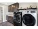 Convenient laundry room with modern washer and dryer, storage cabinets, and wash sink at 5683 Oakmont Blvd, Bargersville, IN 46106