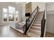 Bright living room featuring a stone fireplace, large windows and carpeted stairs at 5683 Oakmont Blvd, Bargersville, IN 46106