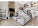 Elegant living room features stone fireplace, wall-mounted TV and staircase to upper level at 5683 Oakmont Blvd, Bargersville, IN 46106