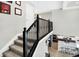 Carpeted staircase with wrought iron railings and view into the modern kitchen at 5683 Oakmont Blvd, Bargersville, IN 46106