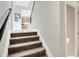 Carpeted staircase leading to an open living area and kitchen at 5683 Oakmont Blvd, Bargersville, IN 46106